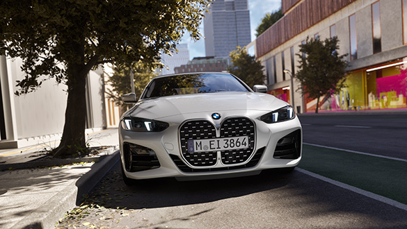 Weißes BMW 4er Cabrio geparkt bei Sonnenlicht in städtischer Umgebung, Frontansicht