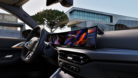Innenraum eines BMW 4er Coupés, mit Fokus auf BMW Curved Display und Lederlenkrad