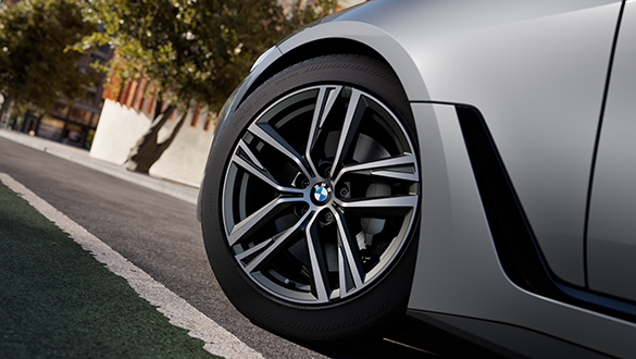 Nahaufnahme des linken Vorderreifens eines grauen BMW 4er Gran Coupé