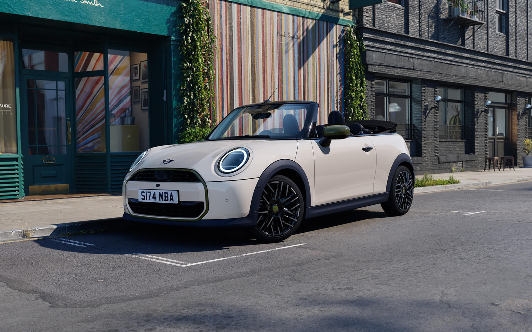 MINI Cabrio Paul Smith Edition mit hellem Exterieur und geöffnetem Verdeck vor einem Paul Smith Store in der Stadt.