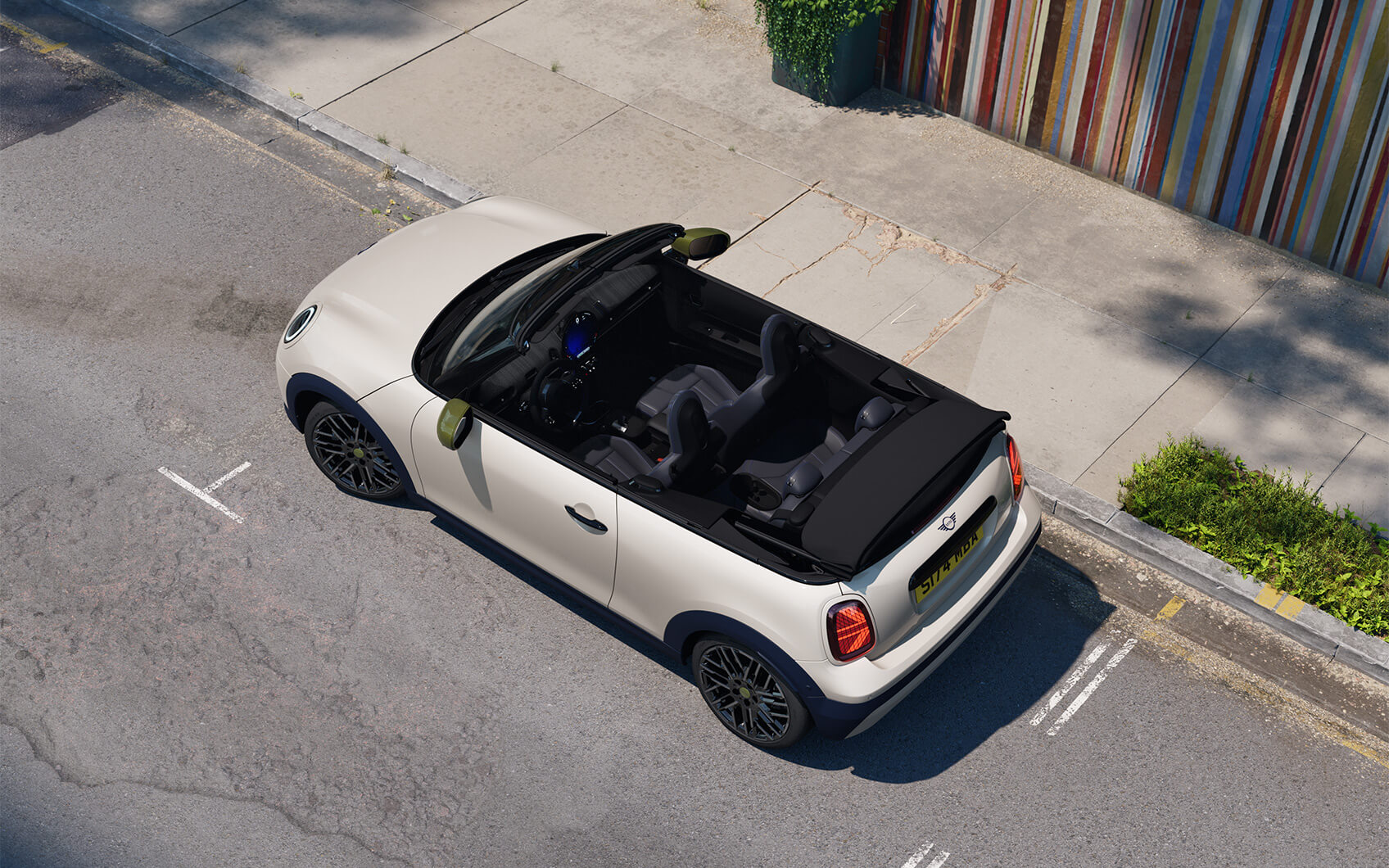 MINI Cabrio Paul Smith Edition mit hellem Exterieur, geöffnetem Verdeck und dunklen Felgen in einer urbanen Straße.