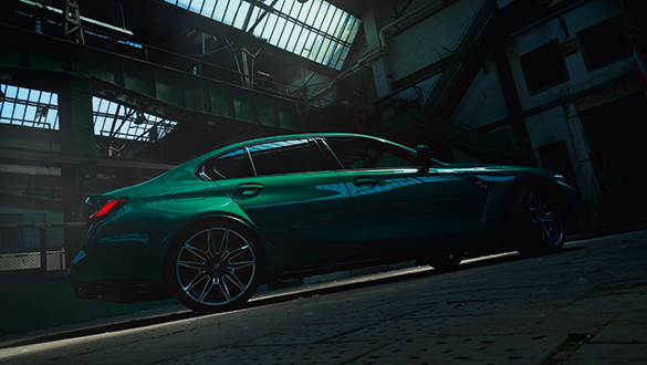 Grüne BMW M3 Limousine seitlich fotografiert in dunkler Industriehalle mit Oberlicht.