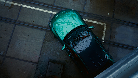 Grüne BMW M3 Limousine von oben in Industriehalle mit Lichtspiegelung auf der Motorhaube.