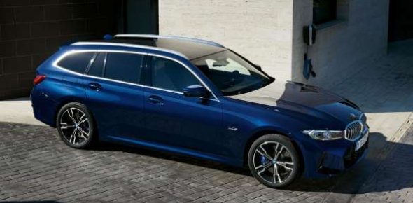 Dunkelblauer BMW 3er Touring PHEV parkt tagsüber draußen in moderner urbaner Umgebung