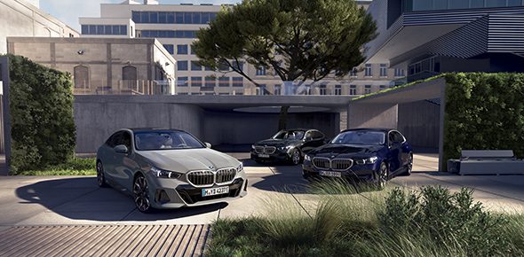 BMW Modelle geparkt vor einem Bürogebäude